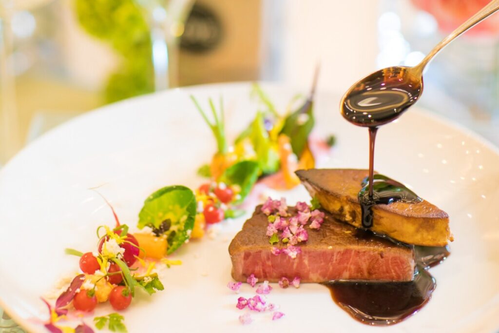 三島の結婚式場ラグシエナの料理。フォアグラと肉料理にソースをかける瞬間を捉えた一皿。