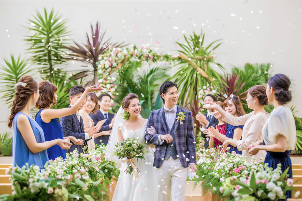 三島の結婚式場ラグシエナでのフラワーシャワー。緑に包まれたガーデンで笑顔の新郎新婦が歩くシーン。