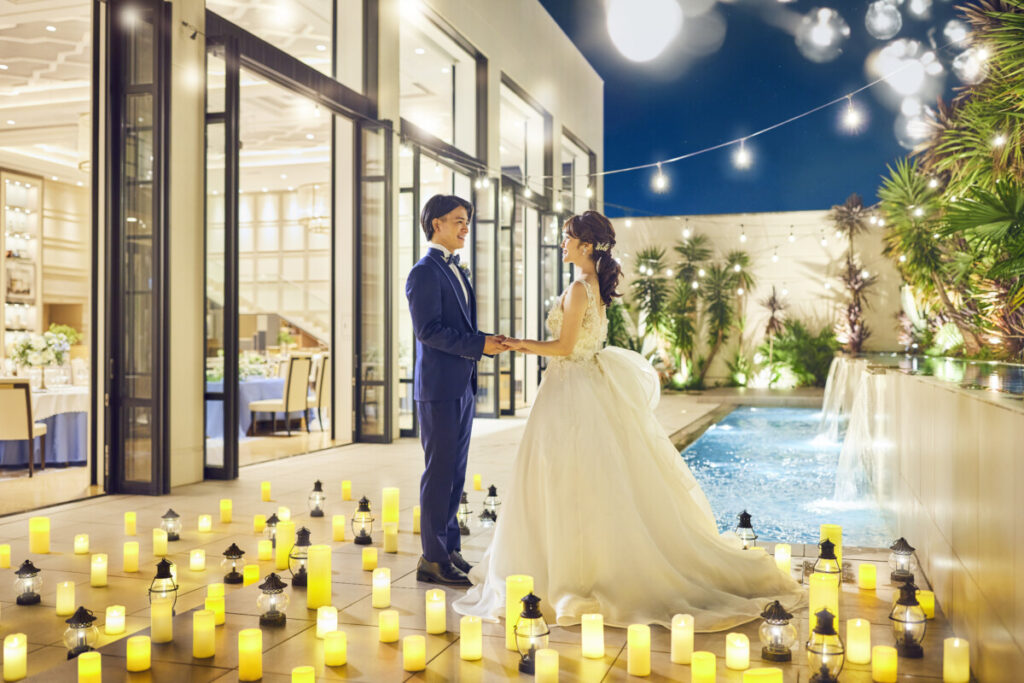 三島の結婚式場ラグシエナのナイトウェディング。キャンドルに包まれた新郎新婦の屋外ショット