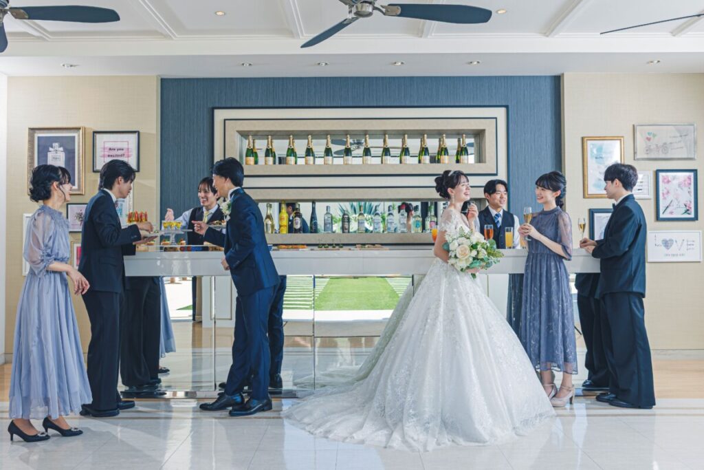三島の結婚式場ラグシエナで、バーカウンターを囲んで談笑する新郎新婦とゲストの様子