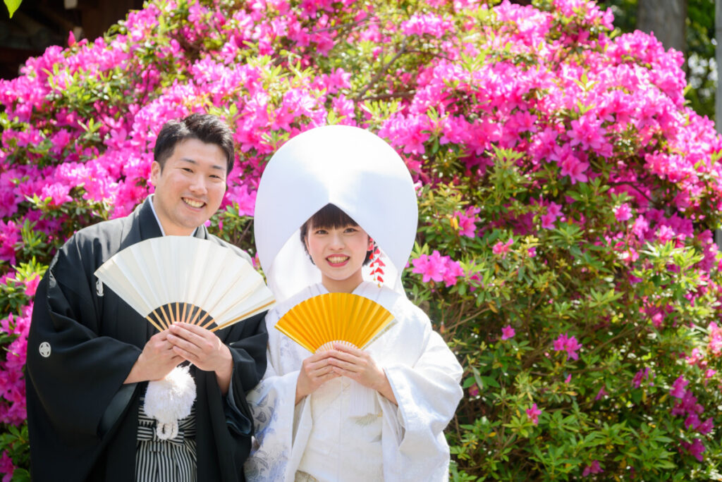 三嶋大社のツツジの前で撮影した和装の新郎新婦。家族婚・少人数婚の結婚式で人気のロケーションフォトで、白無垢と紋付袴が鮮やかな花々に映える一枚。