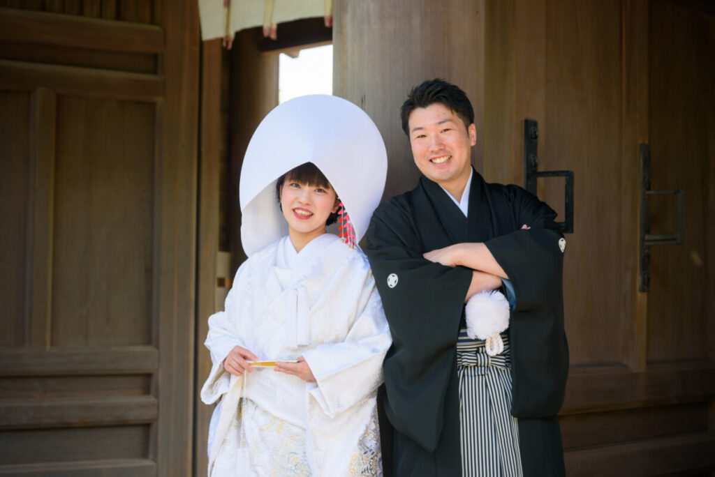 三嶋大社の本殿前で撮影した和装の新郎新婦。家族婚・少人数婚の結婚式で人気のロケーションフォトで、白無垢と紋付袴が神前式の厳かな雰囲気に映える一枚。