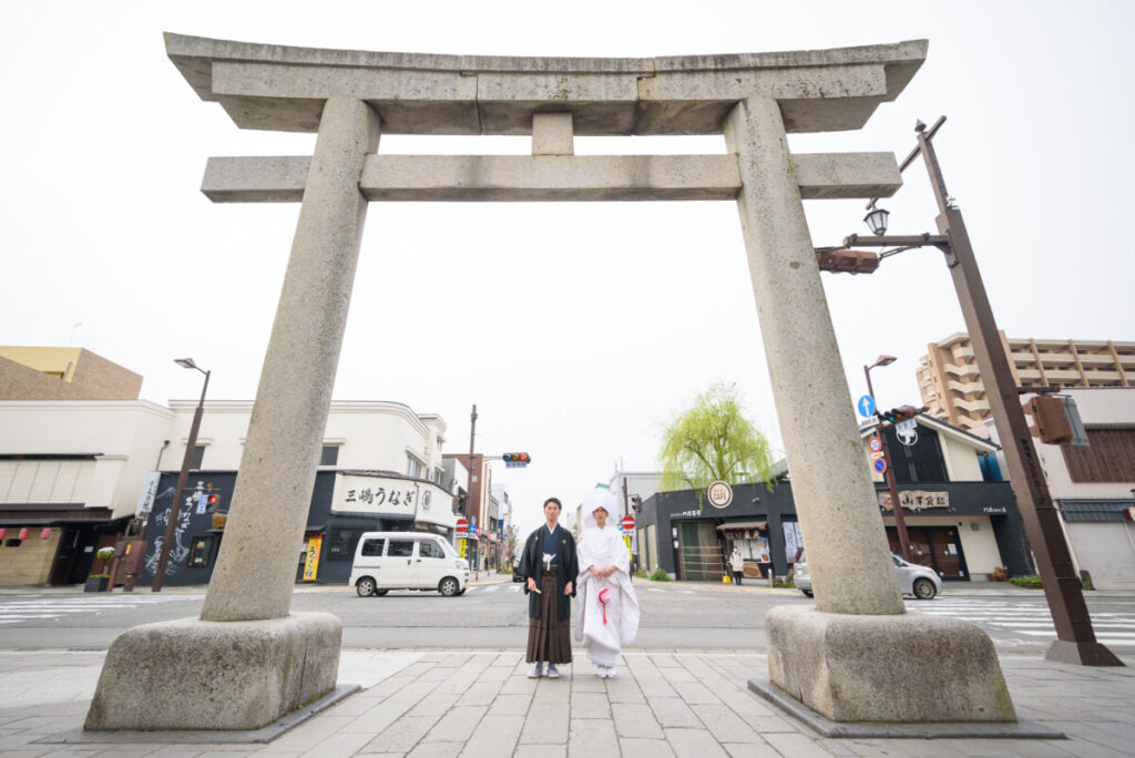 三嶋大社の大鳥居の前で撮影した和装の新郎新婦。家族婚・少人数婚の結婚式で人気のロケーションフォトで、白無垢と紋付袴が映える一枚。