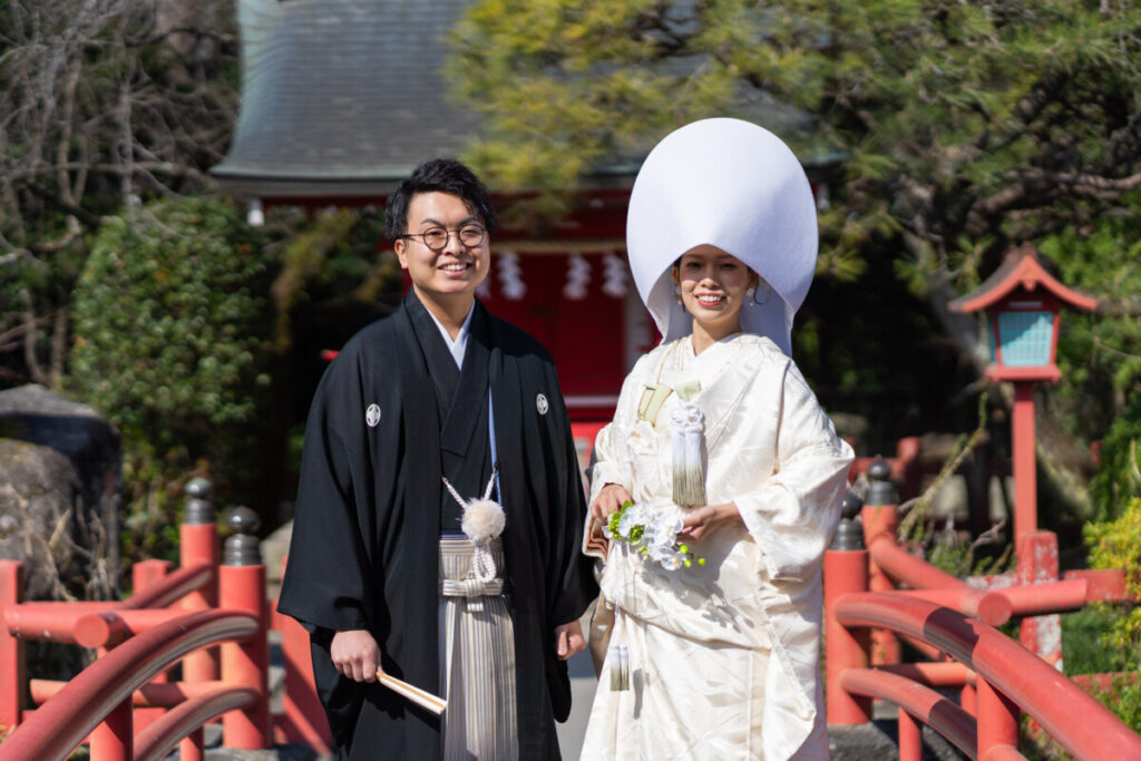 三嶋大社の赤い橋の上で撮影した和装の新郎新婦。家族婚・少人数婚の結婚式で人気のロケーションフォトで、白無垢と紋付袴が美しく映える一枚。