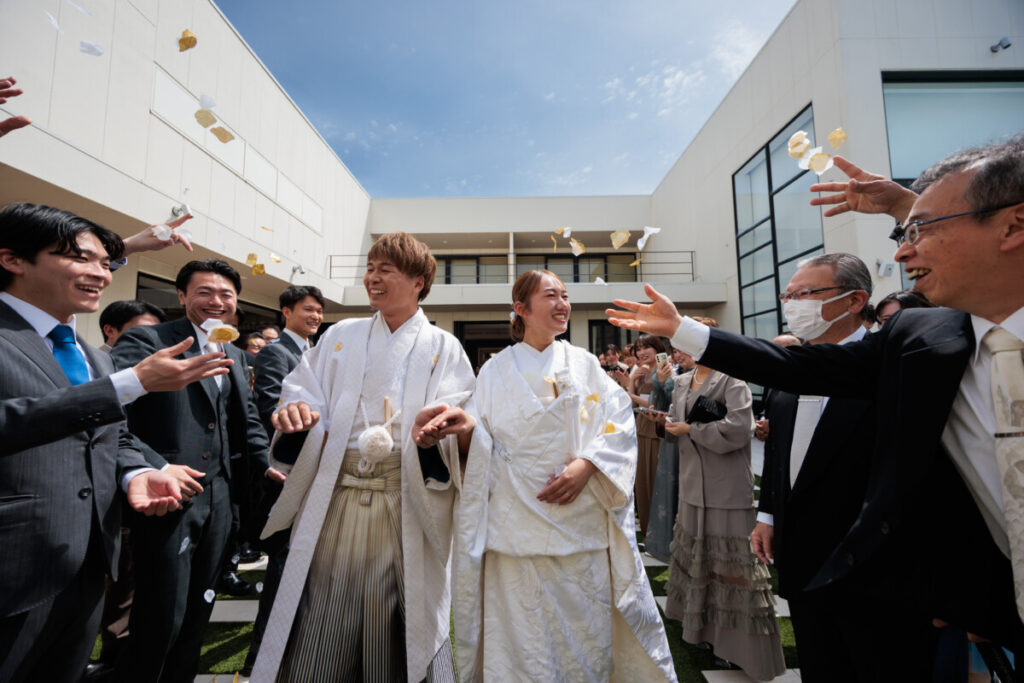 三嶋大社で神前式を挙げた新郎新婦が、参列ゲストに祝福されながら花びらを受けるウェディングレポート写真