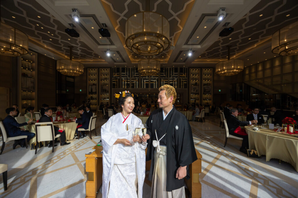 ラグシエナの披露宴会場で和装の新郎新婦がゲストに囲まれて乾杯する様子。富士山本宮浅間大社での神前式後の披露宴シーン。