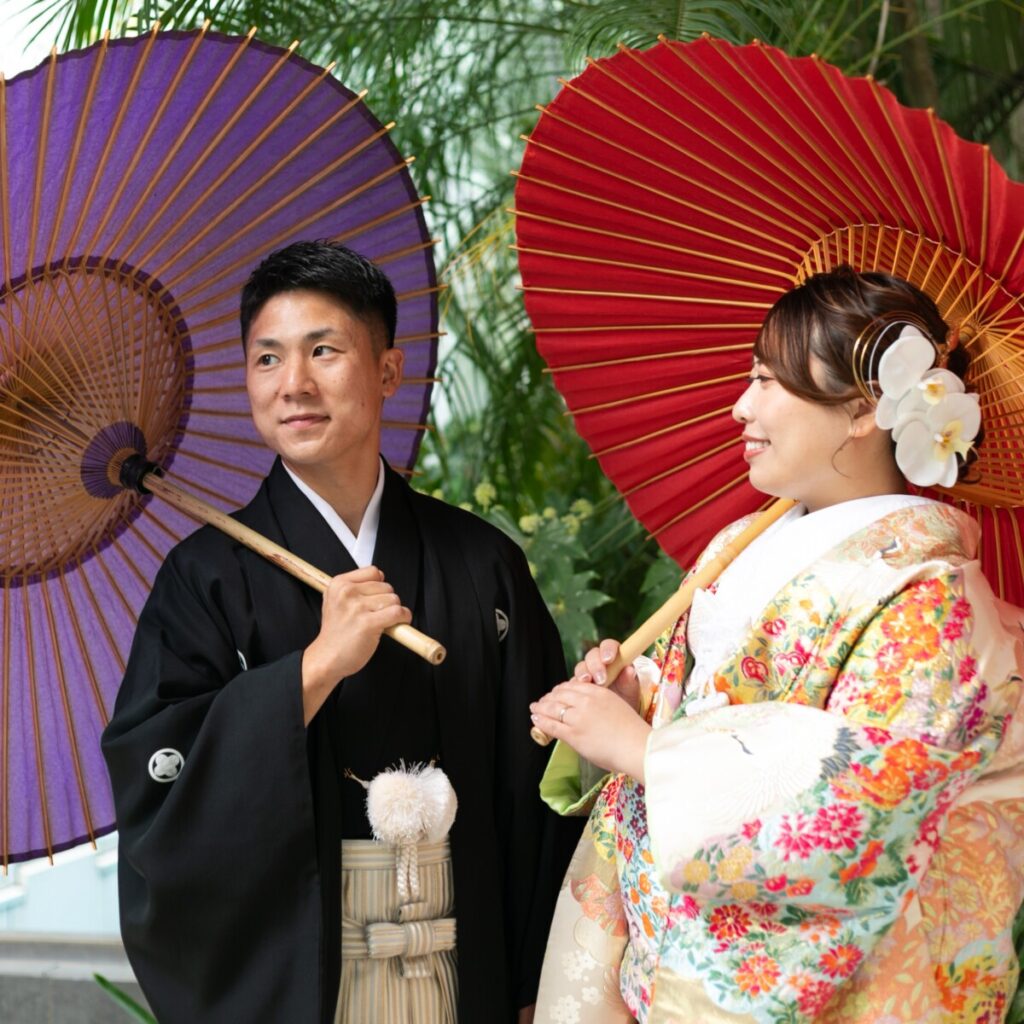 三島・沼津・富士エリアで和装フォトウェディングや前撮りを検討する新郎新婦のロケーションフォト。番傘を手に緑に包まれた屋外で撮影する三嶋大社らしい和婚イメージ。