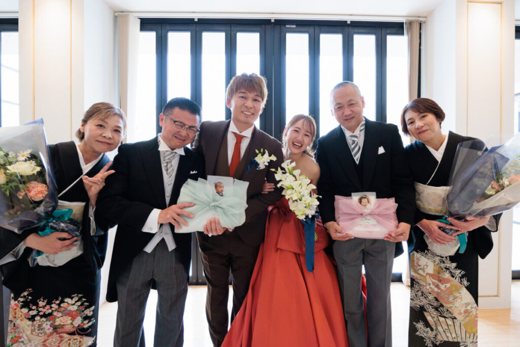 三嶋大社での結婚式後、ラグシエナ披露宴で家族と並ぶ新郎新婦の記念写真。
