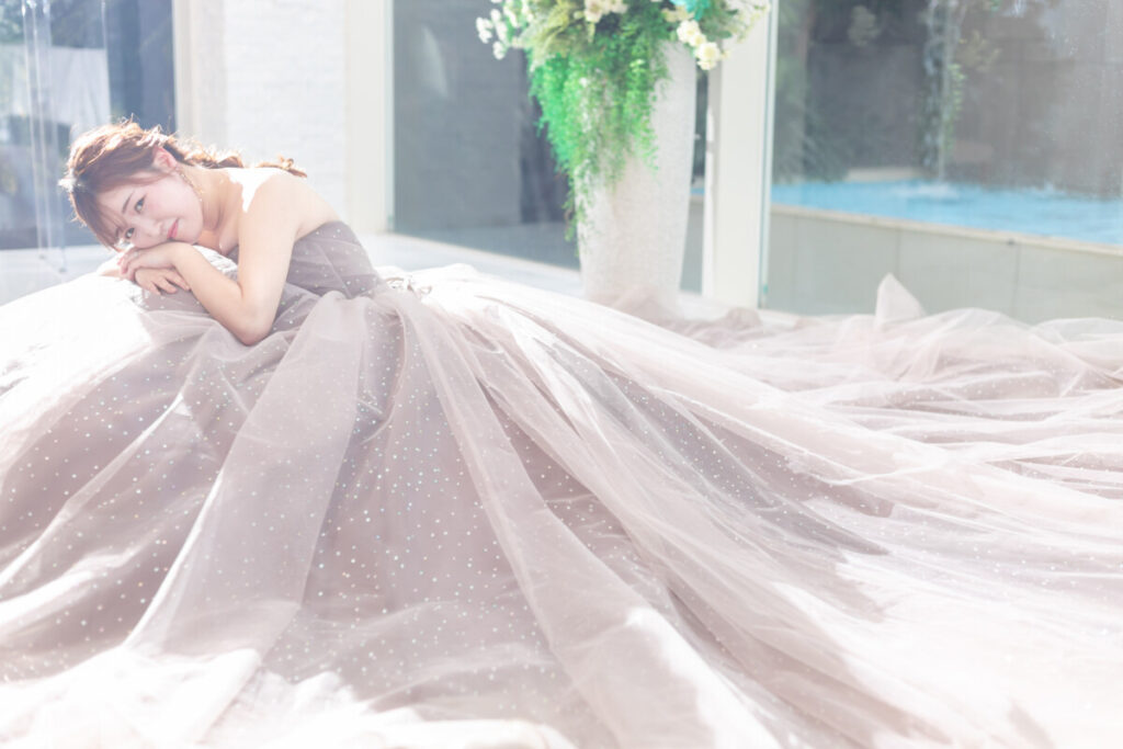 三島・沼津・富士エリアで叶えるフォトウェディング。大きな窓から光が差し込む空間で、ドレス姿の花嫁が佇む美しい一枚