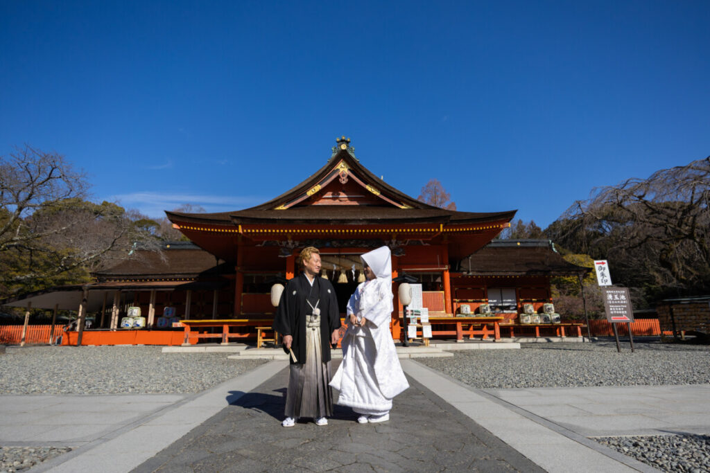 富士山本宮浅間大社の拝殿前に立つ新郎新婦の神前式写真