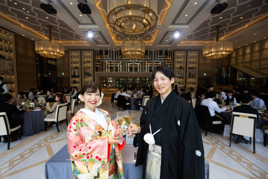ラグシエナの披露宴会場で、和装姿の新郎新婦がゲストと乾杯する華やかなシーン。