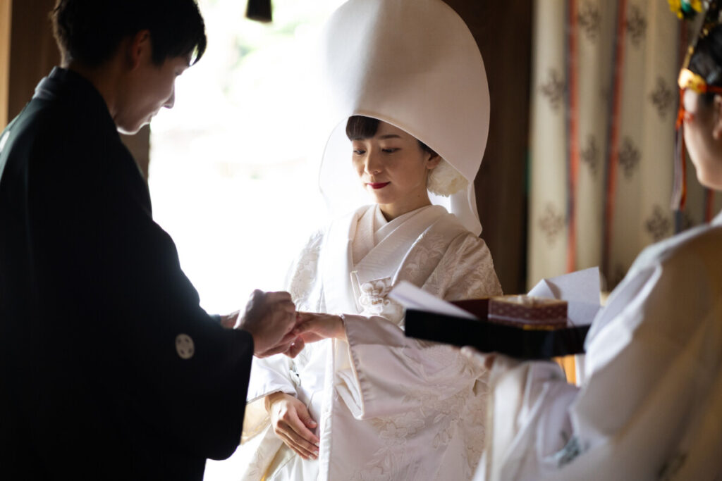 三嶋大社での神前式。新郎が白無垢姿の花嫁に指輪を贈る感動の瞬間。
