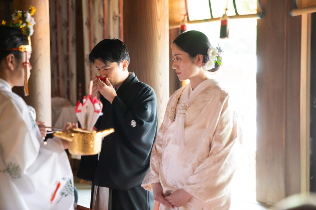 三嶋大社での神前式。新郎が三三九度の儀式で盃を交わす厳かな結婚式の様子。