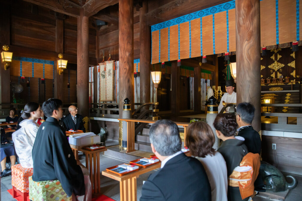 三嶋大社の神前式。神職の祝詞奏上を見守る新郎新婦と家族の様子。