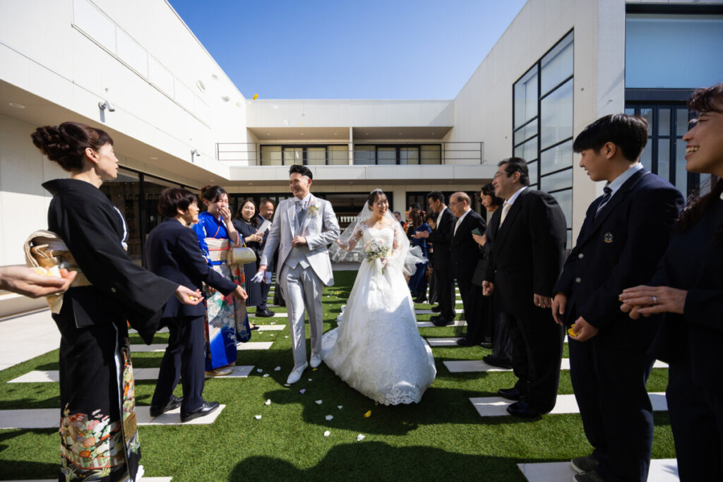 三島・沼津・富士エリアの結婚式場ラグシエナで行われた少人数婚・家族婚のアフターセレモニー。新郎新婦がゲストに祝福されながらフラワーシャワーを受ける、家族だけ 結婚式や親族婚にも人気のアットホームな少人数 結婚式シーン。