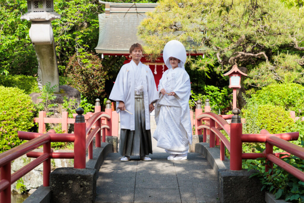 三嶋大社 結婚式で境内の橋に立つ白無垢と袴姿の新郎新婦。披露宴へ続く和婚の美しさを象徴するロケーションフォト。