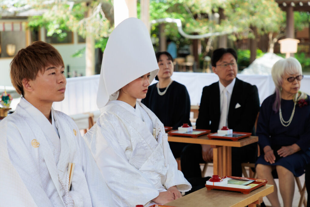 三嶋大社 結婚式で行われる三献の儀。白無垢と袴姿の新郎新婦が神前で儀式を進める厳かなシーンで、披露宴へと続く伝統美を感じる一枚。