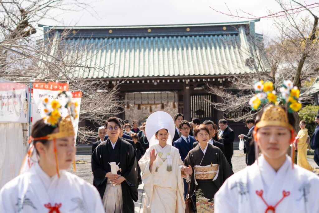 三嶋大社 結婚式の参進の儀。白無垢と袴姿の新郎新婦が巫女に導かれ拝殿へ向かう伝統的な行列で、披露宴へ続く和婚の魅力を伝える一枚。