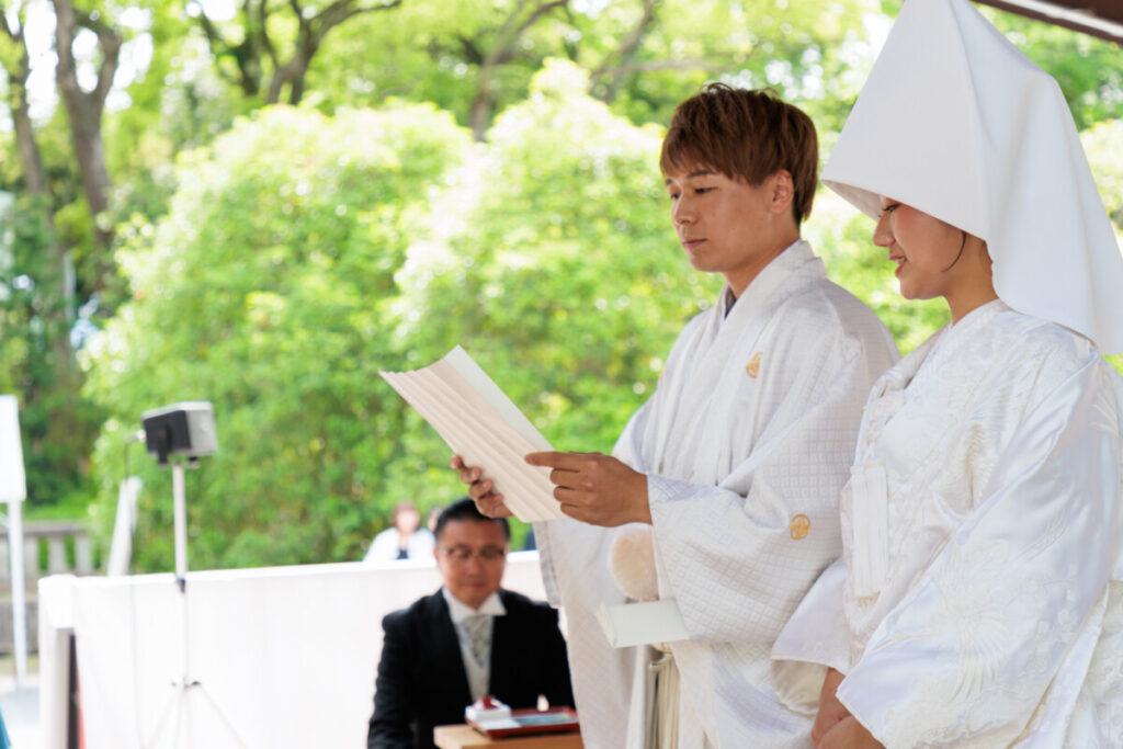 三嶋大社 結婚式の誓詞奏上。白無垢の花嫁と袴姿の新郎が誓いの言葉を読み上げる神前式の核心シーンで、披露宴へ続く厳かな一枚。