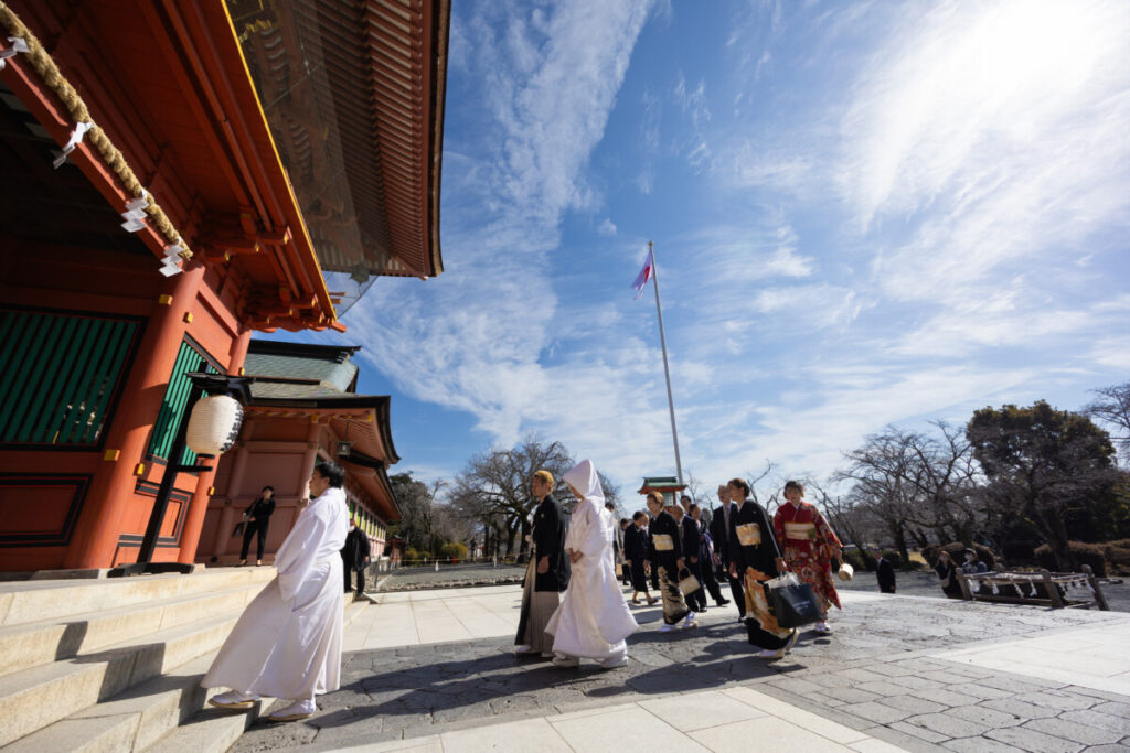浅間大社の神前式で新郎新婦が和装姿で参進し、神職に導かれて拝殿へ向かう様子